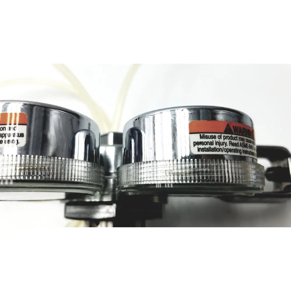 Chrome-finished pressure gauges with ribbed bezels and warning labels on medical graphics corp comprressed gas regulator
