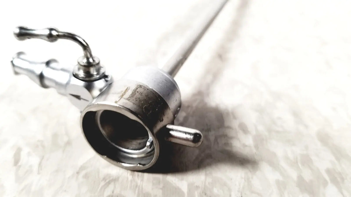 Silver-colored metal medical horizon endoscope with cylindrical body and articulated control handles for single valve use