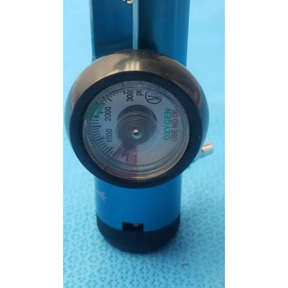 Blue cylindrical medical oxygen barbed regullator 3000 psi with circular gauge and oxygen use no oil warning label