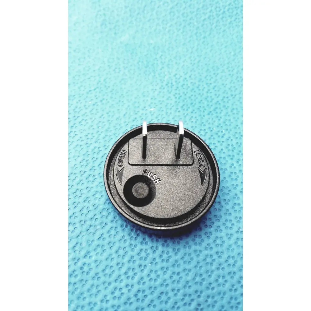 Black circular medical power supply with two metallic prongs and central push button for covidien kangaroo feeding pump