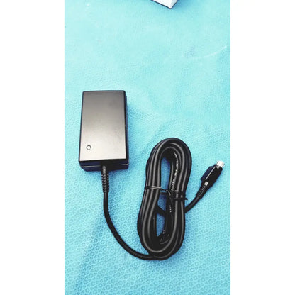 Black rectangular medical power supply with coiled cable and silver-tipped connector for Covidien kangaroo feeding pump