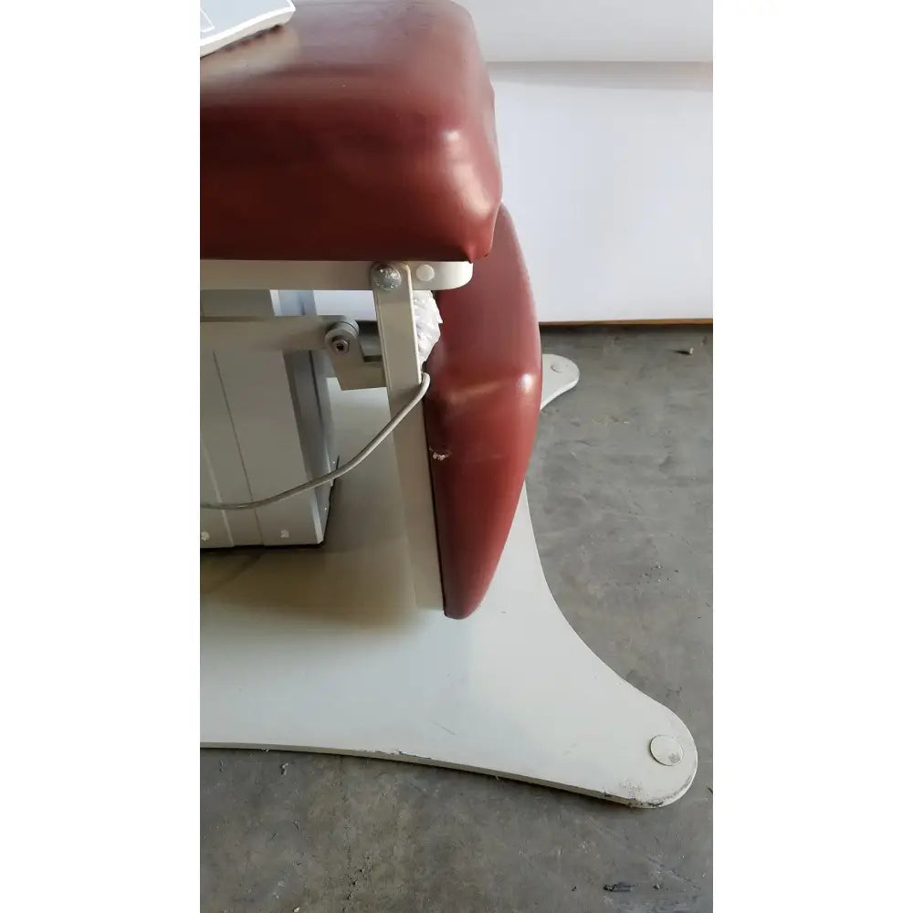 Red padded medical power treatment chair model 8678 with white metal frame and hand control for ergonomic therapy sessions
