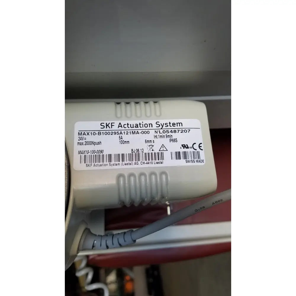 Beige plastic skf actuation system with white label on the back side of a medical power treatment chair model 8678 with hand control