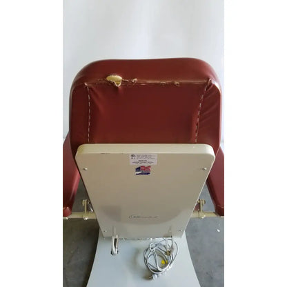 Red vinyl-covered medical power treatment chair model 8678 with white metal frame and attached hand control power cord