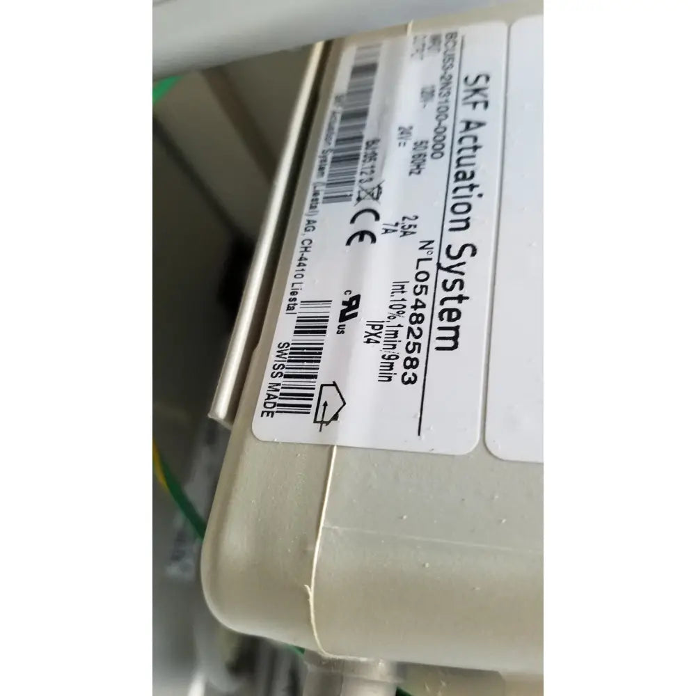 Beige plastic skf actuation system housing with white label showing specifications on medical power treatment chair model 8678