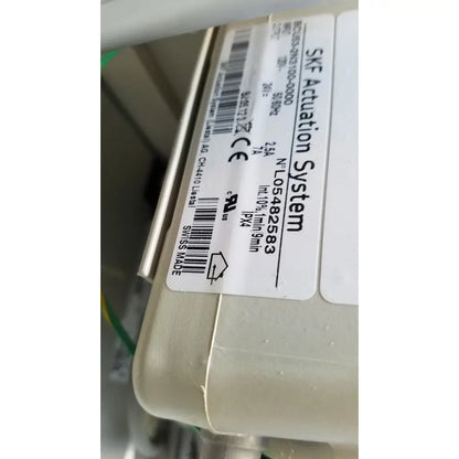 Beige plastic skf actuation system housing with white label showing specifications on medical power treatment chair model 8678