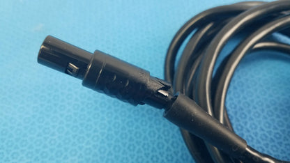 Black coiled medical surgical handpiece console extension cable with matte plastic connector for medical equipment use