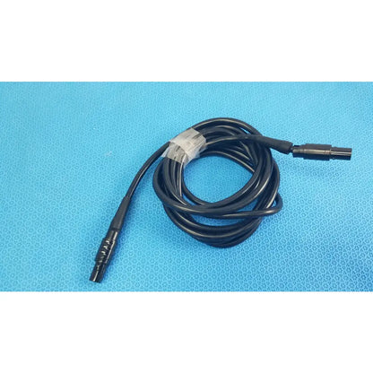 Black coiled medical surgical handpiece console extension cable with two connectors and white label for medical equipment