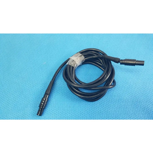 Black coiled medical surgical handpiece console extension cable with two connectors and white label for medical equipment