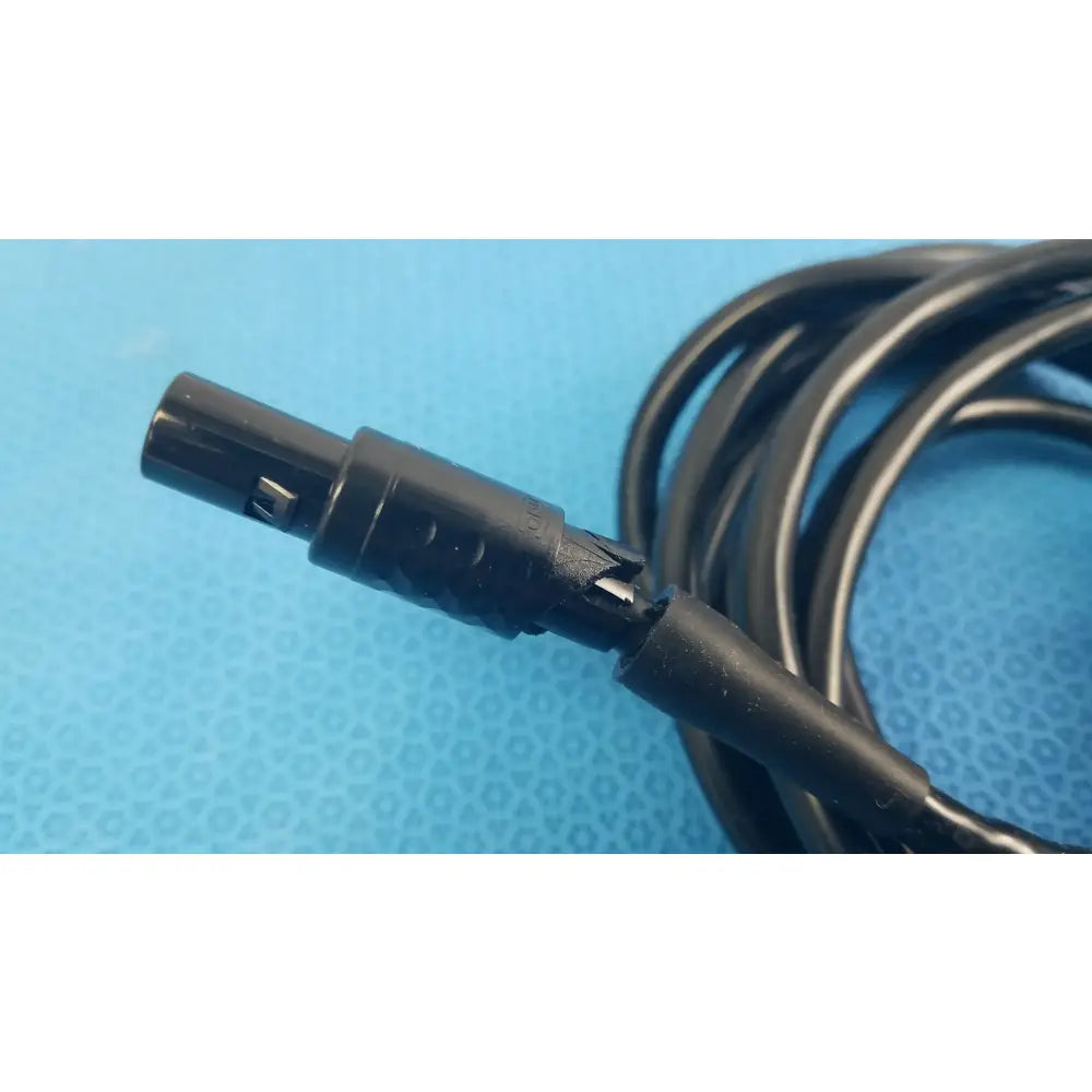 Black coiled medical surgical handpiece console extension cable with matte plastic connector for medical equipment use