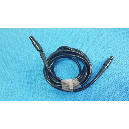 Black coiled medical surgical handpiece console extension cable with two metallic connectors for medical equipment use