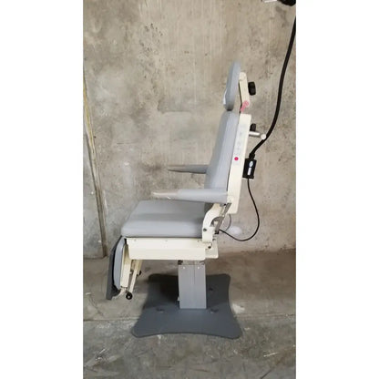 Gray and white adjustable dental chair with padded seating and footrest from medical technology industries power lift exam chair