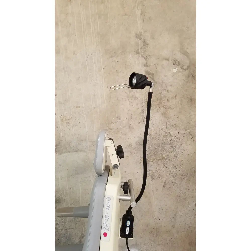 Black gooseneck lamp with flexible hose attached to medical technology industries power lift exam chair