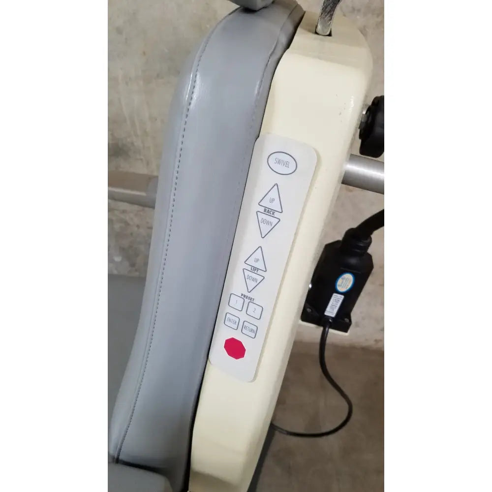Cream-colored medical technology industries power lift exam chair with gray upholstered armrest and adjustable control panel buttons