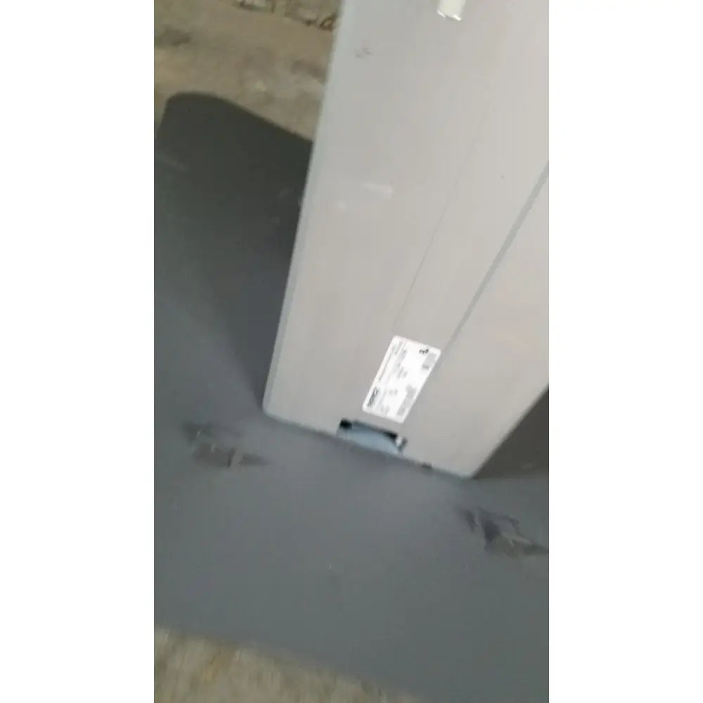 Gray metallic electrical panel with white label on the back of medical technology industries power lift exam chair