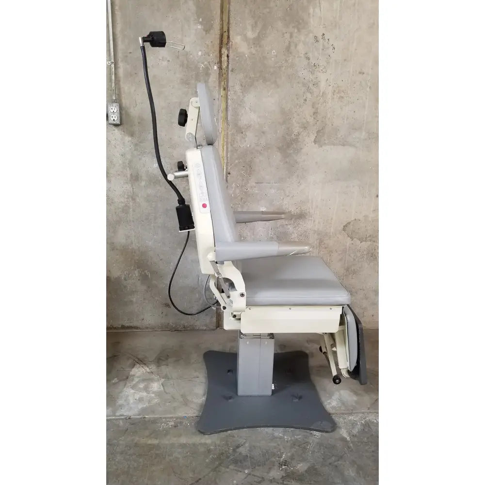 Gray and white padded medical examination chair with adjustable features by medical technology industries power lift