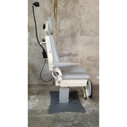 Gray and beige adjustable padded medical examination chair with armrests and headrest by medical technology industries power lift