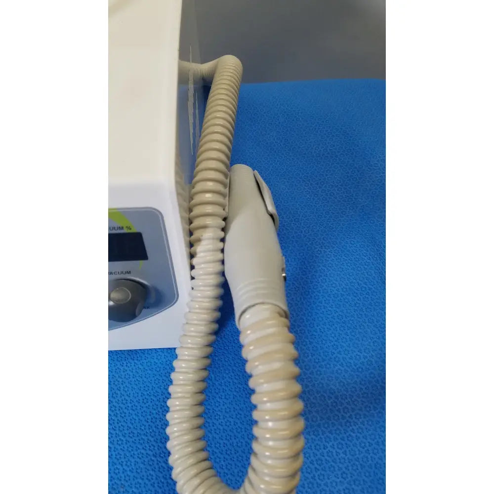 Beige coiled vacuum hose with ergonomic handle attached to white medicool pro vac file v2 dust collector vacuum system