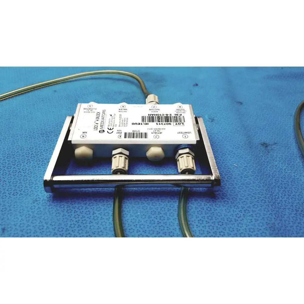 Silver metallic Medivators 907315 hook-up connector assembly with white label and four threaded connectors