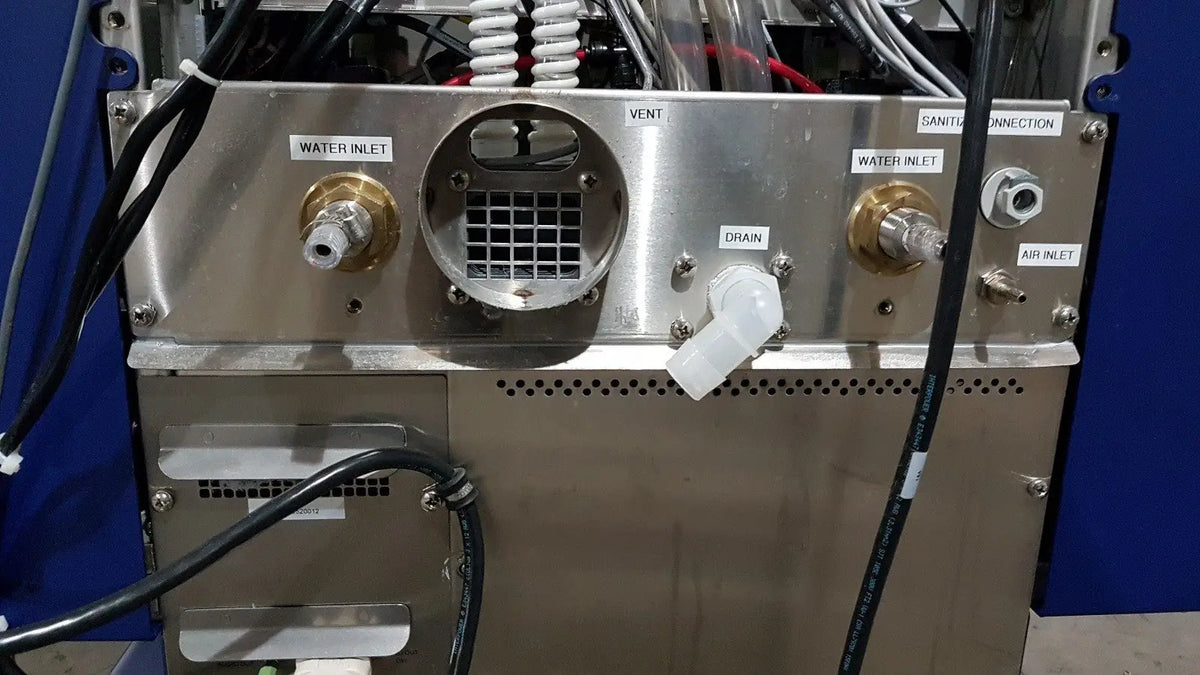 Stainless steel back panel of medivators advantage plus endoscope reprocessor system with labeled water inlet drain and air ports