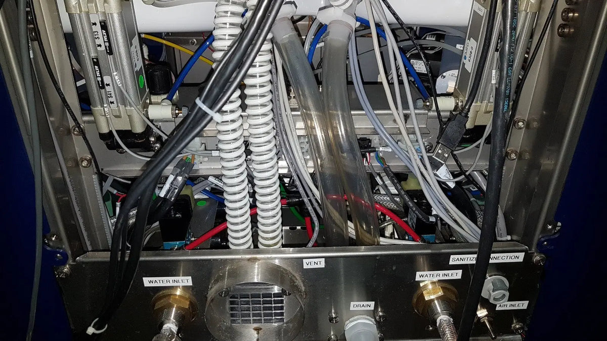 Metallic medivators advantage plus endoscope reprocessor with coiled white tubing and labeled water inlet and air ports