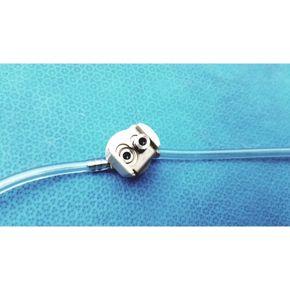 Silver-colored medivators hook-up block unit with two circular ports and clear tube compatible component infusion pump