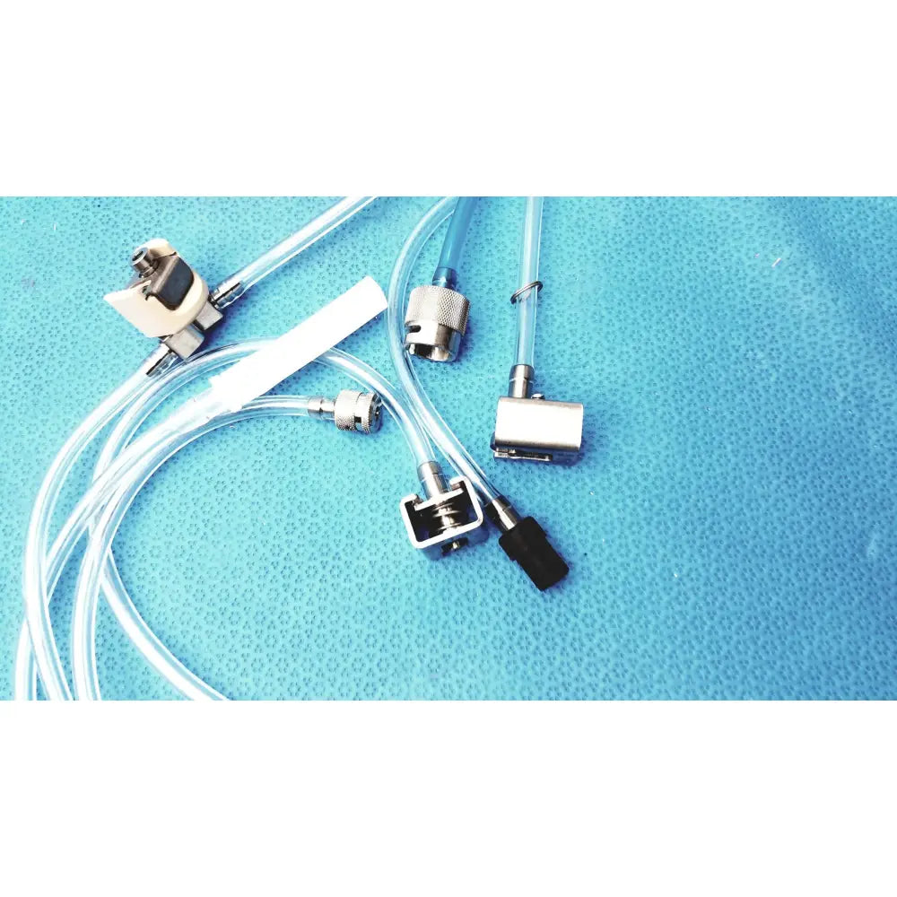 Clear plastic tubing with metallic connectors and black caps on blue surface for medivators hook-up block compatible component