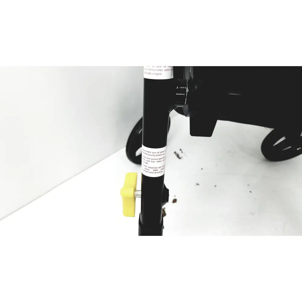 Black metal pole with yellow adjustment knob and white label on medline rolling walker mds8684gblkm with hand brakes