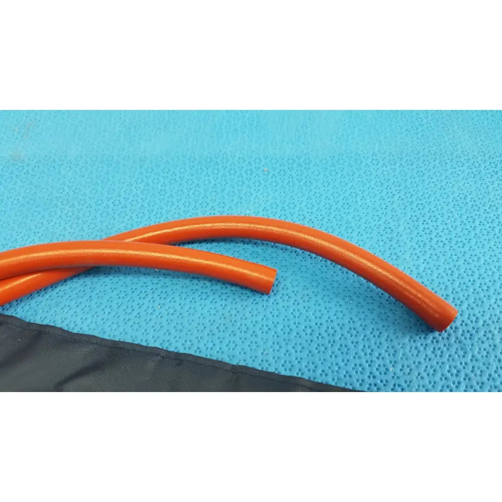 Orange flexible tubing of medline sphygmomanometer artery large blood pressure cuff rests on a blue textured surface