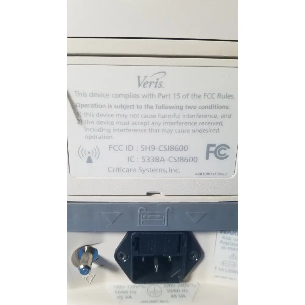 White plastic label with black text and veris logo showing fcc compliance on the back of medrad veris monitoring system for reuse medical use
