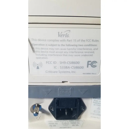 White plastic label with black text and veris logo showing fcc compliance on the back of medrad veris monitoring system for reuse medical use