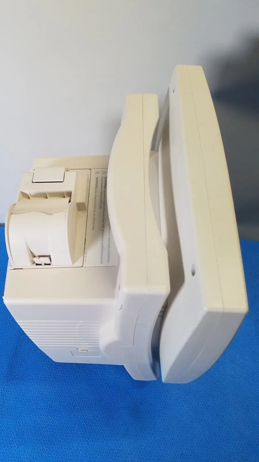 Cream-colored plastic receipt printer with curved top and paper roll compartment for medrad veris monitoring system
