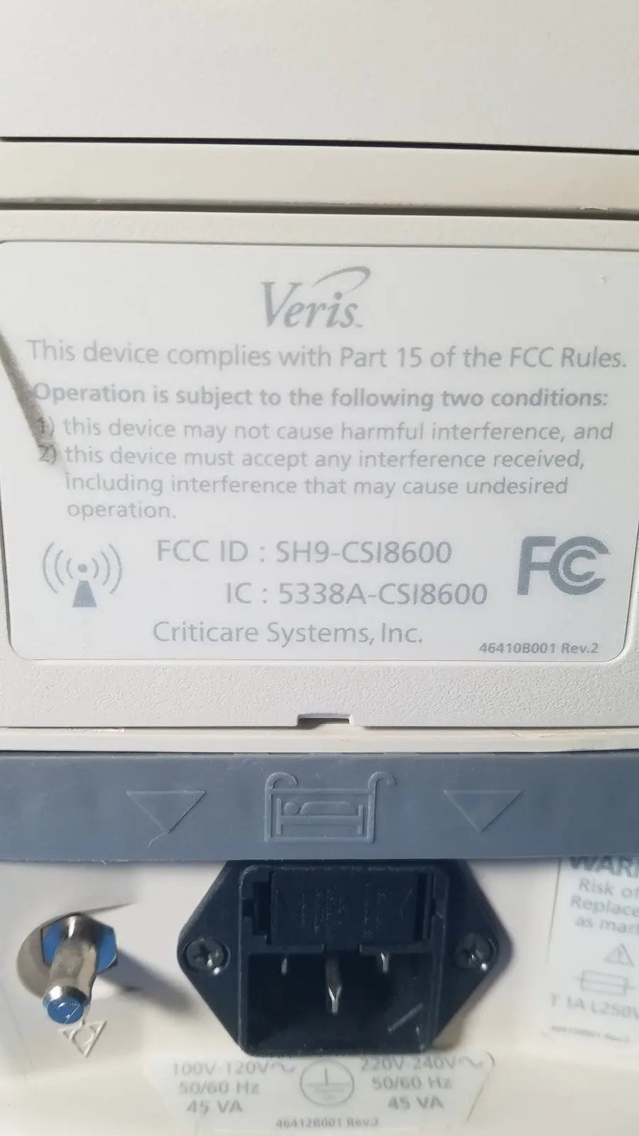 White plastic label with black text and veris logo showing fcc compliance on the back of medrad veris monitoring system for reuse medical use