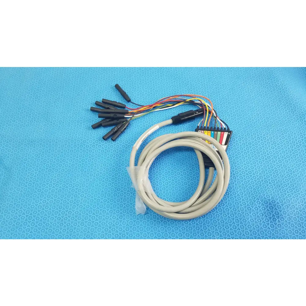 Coiled beige Medtronic 2ACHC catheter ECG cable with multicolored wires and black connectors for medical equipment use