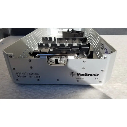 White metal dilators tray with perforated sides and black plastic inserts for reuse medical sterilization trays by Medtronic