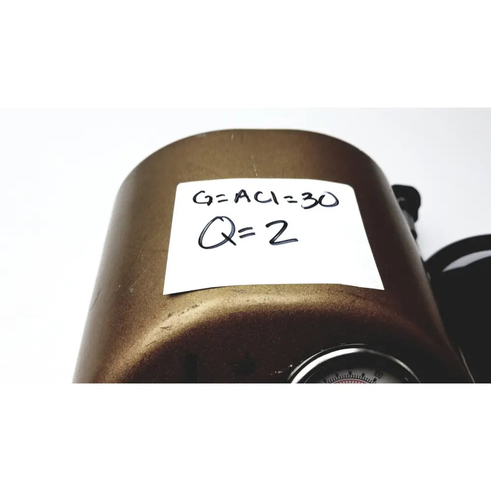 Bronze cylindrical pressure gauge with handwritten measurements on white label for midas rex legend gold pneumatic drill foot control unit
