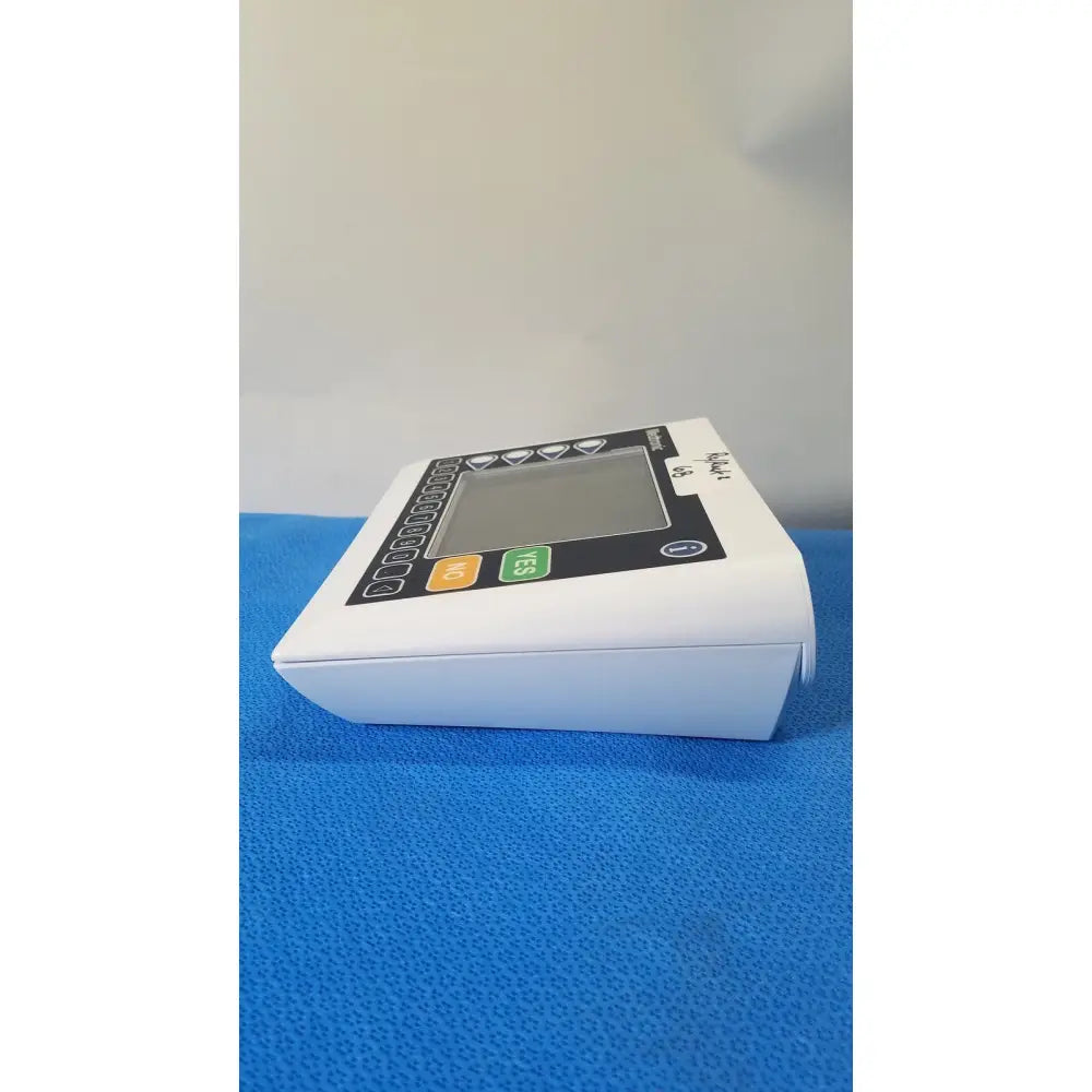 White plastic digital blood pressure monitor with black control panel and colored buttons by medtronic commander flex