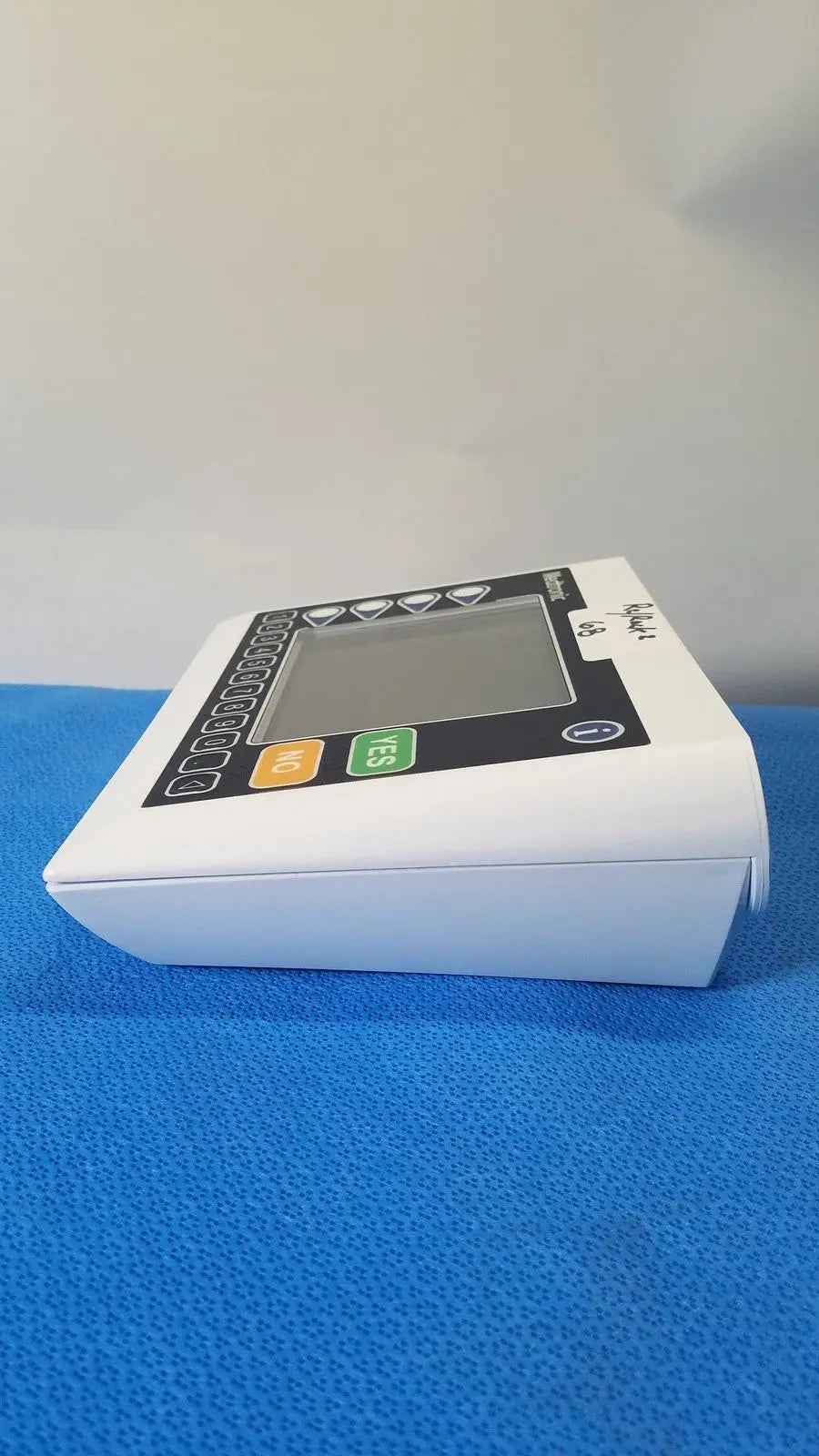 White plastic digital blood pressure monitor with black control panel and colored buttons by medtronic commander flex