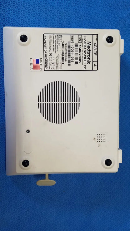 White plastic medtronic commander flex a4lite medical device back with circular vent grille and four mounting screws