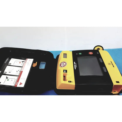 Yellow and black medtronic lifepak 1000 defibrillator with touchscreen and label in a case requiring quik-pak pads and battery for reuse medical