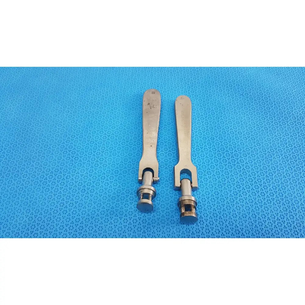 Two metallic medtronic octobase retractor handles with brushed silver finish and u-shaped cylindrical shafts sold as lot of 2