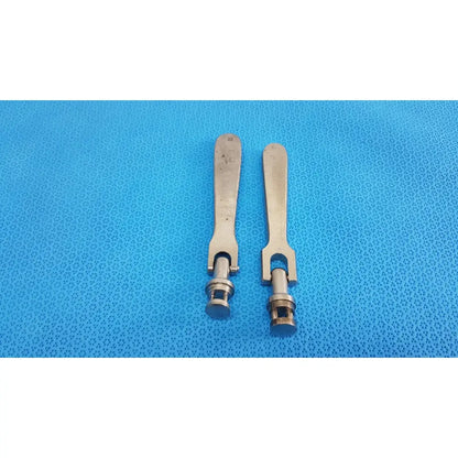 Two metallic medtronic octobase retractor handles with brushed silver finish and u-shaped cylindrical shafts sold as lot of 2