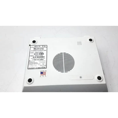 White plastic medtronics commander flex 100011-031 medical device back with circular vent grille and four black mounting holes
