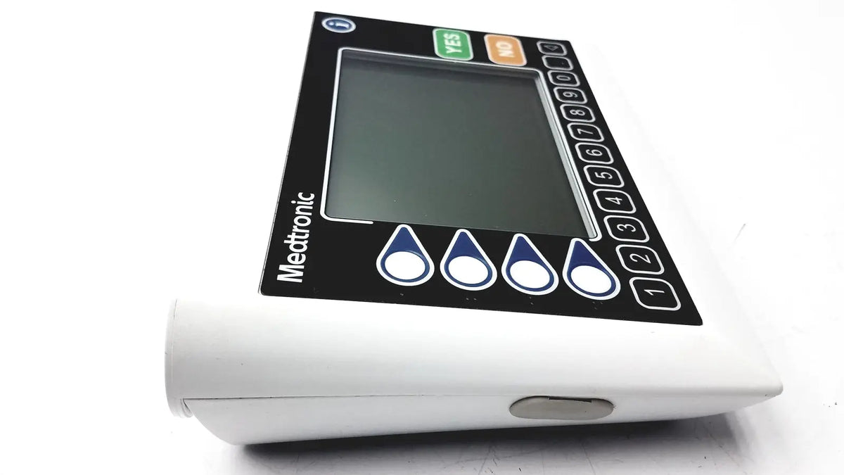 White medtronic insulin pump with black control panel and screen featuring numbered buttons and droplet icons medtronics commander flex