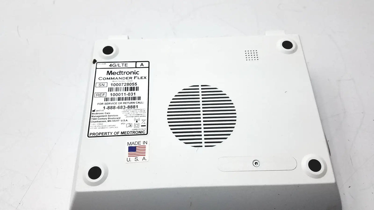 White plastic medtronics commander flex 100011-031 medical device back with circular vent grille and four black mounting holes
