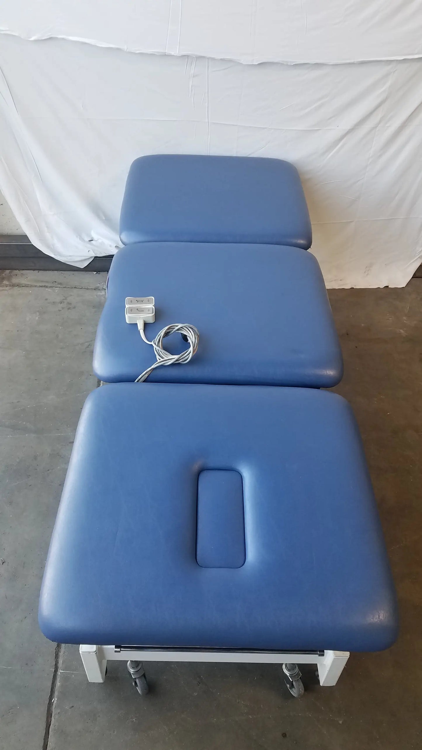 Blue padded metron 3-section electric treatment table with segmented sections and rectangular cutout for electric treatment