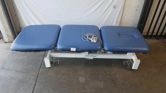 Blue three-section electric treatment table with white metal frame and casters for adjustable electric treatment use