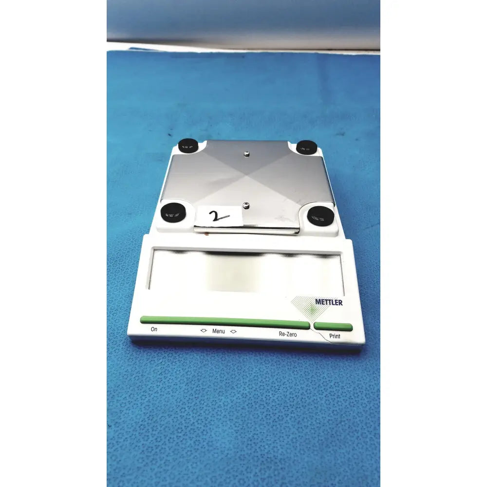 Silver and white mettler bb1200 digital scale with black rubber feet and branded front panel for precise measurements