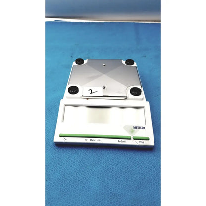 Silver and white mettler bb1200 digital scale with black rubber feet and branded front panel for precise measurements