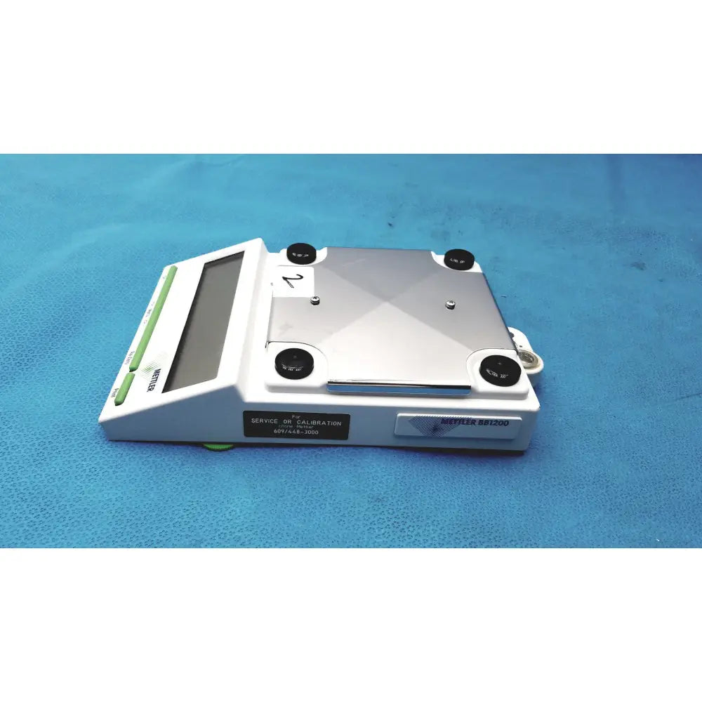 Mettler bb1200 digital scale white and silver with rectangular platform black calibration screws green buttons and display screen
